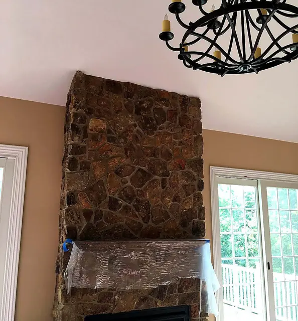 Stone, trim, and a warm field — Stone chimney, tan walls